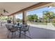 Covered patio with a dining table, chairs, and a view of the landscaped backyard at 21470 E Orchard Ln, Queen Creek, AZ 85142