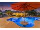 Backyard pool area with underwater lighting and umbrella at 21470 E Orchard Ln, Queen Creek, AZ 85142