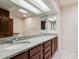 Bathroom featuring double sinks with granite countertops and vanity with wood cabinets at 2201 W Union Hills Dr # 119, Phoenix, AZ 85027