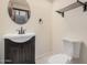 Cozy bathroom features a black vanity, toilet, round mirror, and stylish towel rack at 2201 W Union Hills Dr # 119, Phoenix, AZ 85027