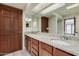 Bathroom featuring double sinks with granite countertops and vanity with wood cabinets at 2201 W Union Hills Dr # 119, Phoenix, AZ 85027