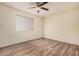 Bright bedroom with modern ceiling fan, wood-look floors, neutral walls and bright window at 2201 W Union Hills Dr # 119, Phoenix, AZ 85027