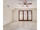 Bright, open living room features ceramic tile and a ceiling fan, with wooden french doors to the exterior at 2201 W Union Hills Dr # 119, Phoenix, AZ 85027
