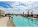 Relaxing rooftop pool featuring lounge chairs, umbrellas, and stunning city views for luxurious leisure at 2211 E Camelback Rd # 402, Phoenix, AZ 85016