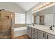 Bathroom with double sinks, walk-in shower, and soaking tub near a glass block window at 2313 E Gondola Ln, Gilbert, AZ 85234