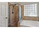 Bathroom featuring a walk-in shower and soaking tub with a glass block window at 2313 E Gondola Ln, Gilbert, AZ 85234