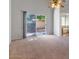 Open living room with neutral carpet and walls, including view to outside through glass door at 2313 E Gondola Ln, Gilbert, AZ 85234