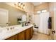 Bathroom with vanity sink, framed mirror, shower, and tiled flooring at 23216 N Gaviota Dr, Sun City West, AZ 85375