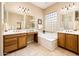 Spacious bathroom with double sinks, vanity, large bathtub with glass block window, and tiled flooring at 23216 N Gaviota Dr, Sun City West, AZ 85375