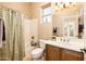 Well-lit bathroom featuring vanity, shower-tub combo, and tiled flooring at 23216 N Gaviota Dr, Sun City West, AZ 85375