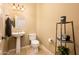 Pedestal sink with matching toilet, shelving, and tiled flooring at 23216 N Gaviota Dr, Sun City West, AZ 85375