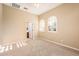 Neutral bedroom featuring plush carpet, arched windows, and bathroom entrance at 23216 N Gaviota Dr, Sun City West, AZ 85375