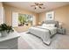 Cozy bedroom featuring neutral tones, plush carpeting, a comfortable bed, and a window offering scenic views at 23216 N Gaviota Dr, Sun City West, AZ 85375
