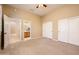 Neutral bedroom featuring plush carpet, ceiling fan, and double door closet at 23216 N Gaviota Dr, Sun City West, AZ 85375
