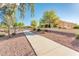 Exterior view of landscaped walkway and retaining wall with mature trees at 23216 N Gaviota Dr, Sun City West, AZ 85375