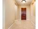 Inviting foyer featuring neutral tile flooring and a solid wood front door at 23216 N Gaviota Dr, Sun City West, AZ 85375