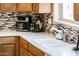Kitchen counter with modern appliances, white countertop, and tile backsplash at 23216 N Gaviota Dr, Sun City West, AZ 85375
