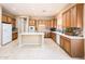 Well-lit kitchen featuring wood cabinets, white appliances, a center island and stylish backsplash, perfect for cooking at 23216 N Gaviota Dr, Sun City West, AZ 85375