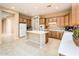 Spacious kitchen with wood cabinets, white appliances, a center island, and tiled floors, perfect for a home chef at 23216 N Gaviota Dr, Sun City West, AZ 85375