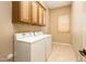 Well-lit laundry room with tile floors, cabinets, and modern washer and dryer at 23216 N Gaviota Dr, Sun City West, AZ 85375