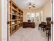 Home office with custom built-ins, a ceiling fan, and ample natural light from bay windows at 23216 N Gaviota Dr, Sun City West, AZ 85375