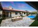 Stunning backyard featuring a pool, fire pit, travertine tile, lush greenery, and a red tile roof at 2421 E Montebello Ave, Phoenix, AZ 85016
