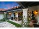 Beautiful backyard patio area with an outdoor table, red tile roof, and lush, green landscaping at 2421 E Montebello Ave, Phoenix, AZ 85016