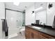 Modern bathroom features wood vanity, dark countertop, stylish mirror, and tiled shower-tub combination at 2421 E Montebello Ave, Phoenix, AZ 85016