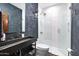 Stylish bathroom boasts decorative wallpaper, unique light fixture, and glass-enclosed shower at 2421 E Montebello Ave, Phoenix, AZ 85016