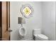 This half-bathroom features a toilet and urinal, and an attractive stained glass window at 2421 E Montebello Ave, Phoenix, AZ 85016