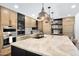 Gorgeous kitchen with an island and sink, tan cabinetry, tile backsplash, and stainless steel appliances at 2421 E Montebello Ave, Phoenix, AZ 85016