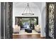 Bright living room featuring elegant wrought iron door, chandelier, and stylish sofas at 2421 E Montebello Ave, Phoenix, AZ 85016