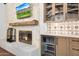 Cozy living room features a stone fireplace, wooden mantle, and a built-in beverage fridge at 2421 E Montebello Ave, Phoenix, AZ 85016