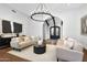 Stylish living room featuring a modern chandelier, comfortable seating, and dark wood flooring at 2421 E Montebello Ave, Phoenix, AZ 85016