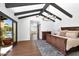 This spacious main bedroom features wooden ceiling beams, access to the backyard pool, and an elegant chandelier at 2421 E Montebello Ave, Phoenix, AZ 85016