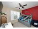 Cheerful bedroom featuring neutral walls with a vibrant red accent wall and a ceiling fan at 2424 E Aster Dr, Phoenix, AZ 85032