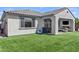 Backyard view with modern fireplace on patio, lush green lawn, and landscaped yard at 24540 N 144Th Ave, Surprise, AZ 85387