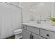 Bright bathroom featuring a neutral color scheme, with gray vanity, white sink, and toilet at 24540 N 144Th Ave, Surprise, AZ 85387