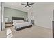 Spacious bedroom with neutral carpet, an accent wall, and a view into the connected bathroom at 24540 N 144Th Ave, Surprise, AZ 85387