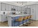 Modern kitchen with gray cabinets, stainless appliances, and a large island with bar seating at 24540 N 144Th Ave, Surprise, AZ 85387