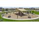 Community playground with a covered play structure, swings, and seating area, perfect for Gathering fun and outdoor activities at 24540 N 144Th Ave, Surprise, AZ 85387