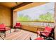Covered balcony with desert views, concrete floors, four red chairs, and colorful stripped rug at 250 W Queen Creek Rd # 206, Chandler, AZ 85248
