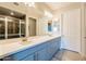 Bathroom featuring double sinks, light grey cabinets, large mirror, and tile shower with glass door at 250 W Queen Creek Rd # 206, Chandler, AZ 85248