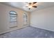 Empty bedroom with neutral carpeting, ceiling fan, and natural light from windows at 2502 E Malibu Dr, Tempe, AZ 85282