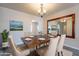 Dining room with chandelier, a large mirror, seating for six, and bright light at 2502 E Malibu Dr, Tempe, AZ 85282