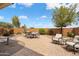 Beautiful backyard patio area with brick pavers, dining table and chairs, and comfortable outdoor seating at 27030 W Escuda Dr, Buckeye, AZ 85396