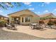 Spacious backyard features a brick-paver patio, lush desert landscaping, seating, and a covered patio at 27030 W Escuda Dr, Buckeye, AZ 85396