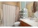 Well-lit bathroom with a shower/tub, white decorative shelving, and a wood-framed vanity at 27030 W Escuda Dr, Buckeye, AZ 85396