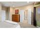 Bedroom with a view into the bathroom, wood dresser, and neutral paint colors at 27030 W Escuda Dr, Buckeye, AZ 85396