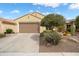 Attractive home exterior with a two-car garage, desert landscaping, and a neutral color scheme at 27030 W Escuda Dr, Buckeye, AZ 85396